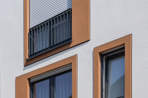  Die Fensterfaschen wurden in Brauntönen sowie mit einem Glattputz gestaltet und durch einen schwarzen Akzentstrich zwischen vorstehender Fensterfasche und Hauptfassade abgesetzt  