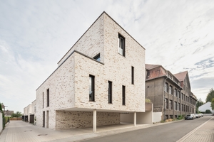  Das Wohnquartier ist eine Neuinter-pretation des partiell denkmalgeschützten Areals. Rechts im Bild: das erhaltene Hauptgebäude der ehemaligen Gesangbuchfabrik, links davon befindet sich das neue 6-Parteien-Haus, dahinter drei neue Einfamilienhäuser 