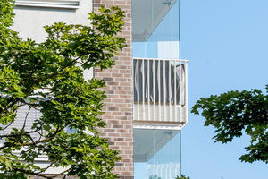  Verglaste Balkone und vor die Fenster montierte Fassadenverglasungen  schützen die Bewohner vor dem Lärm der vielbefahrenen Straße 