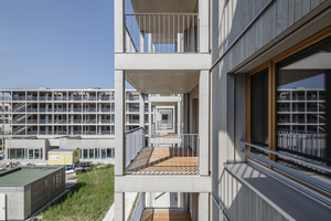  Das L-förmige Wohngebäude mit vorgelagerten Balkons umschließt die Hälfte eines großzügigen Innenhofs 