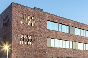  Die Fassaden bestehen aus rotem Klinker und werden durch horizontale Fensterbänder in dunklem Anthrazit gegliedert 