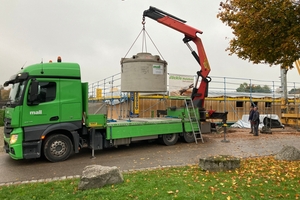  Lieferung des unterirdischen Regenspeichers PF 7600 aus Betonfertigteilen, mit integriertem Filterkorb im Zulauf und werkseitig vormontierten Wanddurchführungen für Zu- und Überlauf sowie einem Leerrohr als Verbindung zum Regencenter im Gebäude 