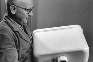  Ein Technischer Berater präsentiert einen der frühen Spülkastenmodelle aus PVC. Die Spülkästen komplett aus Kunststoff waren eine Weltneuheit in den 1950er-Jahren. 