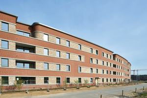  Farblich abgesetzte Mauerwerksbänder in Verbindung mit Betonfertigteilen betonen die Horizontalität der Fassade. Großformatige Kalksandsteinelemente bilden die tragende Schicht 