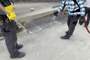  Die Flächenabdichtung wurde mit Triflex ProTect durchgeführt, die Detailabdichtung mit Triflex ProDetail. Während ein Maschinenführer die Abdichtung aufsprüht, verschlichtet ein zweiter Mitarbeiter das Material mit einer Rolle an 