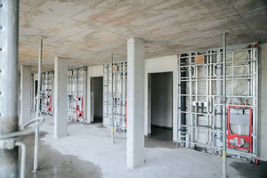  Blick auf eine Etage mit fertig installierten Installationswänden und der ausgehärteten Filigrandecke, die das Stockwerk nach oben hin abschließt 