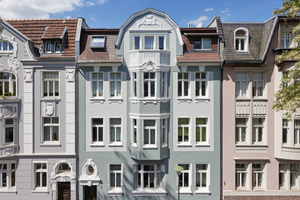  Zwischen Gebäuden in Grau und Rosé fügt sich das Mehrfamilienhaus nach seiner Sanierung harmonisch ein. Der Meisterbetrieb Heßbrüggen setzte bei der Fassadengestaltung Produkte auf Silicon-Basis ein 