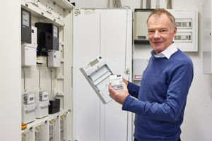  Autor Gero Lücking, Head of Smart Metering bei Techem, hält einen digitalen Stromzähler in der Hand. In Verbindung mit dem Smart Meter Gateway ergibt er ein intelligentes Messsystem 