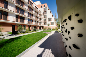  An der teils terrassenförmig abgestuften Rückseite erweitern langgestreckte Balkone den Wohnraum in Richtung eines begrünten Innenhofs 