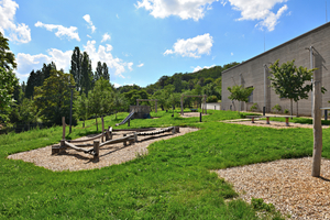  Ein vielseitiger Spielplatz mit Rutschen, Schaukeln, Klettergerüsten und Sandkästen, umgeben von grüner Natur 