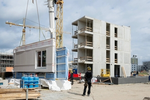  Das erste vorgefertigte Wandelement in Holzrahmenbauweise des „Typenhaus Eco“ wird vom Kran zur Montage verladen  