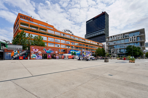  Außenansicht des WERK3 mit Büros und vielseitiger Gastronomie, Werk 4 mit einem Hostel und einem Hotel, Werk 12 mit Büros und Fitnessclub (inkl. Schwimmbad) sowie des Container Collectives im Vordergrund mit Ateliers und Gastronomie 