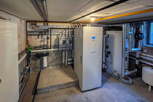  Ein modernisierter Technikraum mit Wärmepumpen-Inneneinheit und neuem Speichermodul 