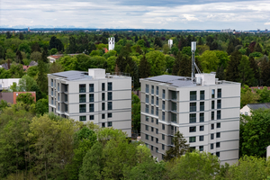 In München werden zwei fünfgeschossige Punkthäuser seriell nach dem Energiesprong-Prinzip saniert und um drei zusätzliche Stockwerke in klimaneutraler Holzmassiv- und Holzrahmenbauweise nachverdichtet 