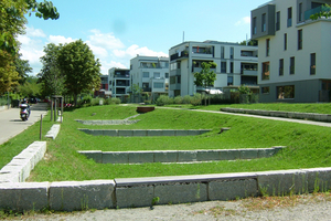  Freiburg im Breisgau, Wohnquartier Östlich Wiehrebahnhof: Im abschüssigen Gelände liegen leicht vertieft Sickerbeete als ebene Grasflächen, kaskadenartig miteinander verbunden. Die Zuläufe sind als offene Rinnen ausgeführt 