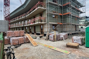  Die Ziegel-Außenwände bekleidet eine Holzverschalung und statt die Stahlbetonwände und -decken in den Wohnungen und Treppenhäusern zu verspachteln, erhalten sie einen lasierenden Anstrich 