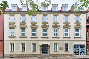  Augenscheinlich die ursprüngliche Fassade mit aufgefrischten Farben – Passantinnen und Passanten erblicken eine neoklassizistische Gebäudehülle 