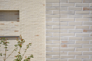  Die Fassaden der Bestandsgebäude sind mit schlanken, hellen Klinker-Riemchen  gestaltet und betonen den industriellen Charakter des historischen Ensembles 