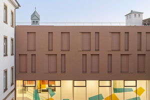  Die Nachverdichtung erforderte eine sensible Einbindung des Neubaus in die Bestandsarchitektur. Der monolithisch wirkende Baukörper mit grobkörniger Putzfassade fügt sich stimmig in die bestehende Architektur ein. 