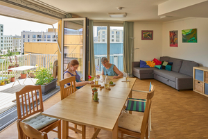  Mehrere Haushalte teilen sich einen großen Gemeinschaftsraum, außerhalb der eigenen Wohnung 