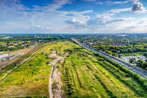  Blick auf die Potenzialfläche für das Projekt Duisburger Dünen zwischen Hauptbahnhof mit seinen Gleisen links und der Stadtautobahn A 59 rechts 