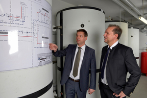  Andre Siegel, Junkers (links), und Ulrich Farwick, Vivawest (rechts), nahmen gemeinsam die Anlage in Betrieb. In den sechs Heizungspufferspeichern werden die Solarerträge gespeichert 