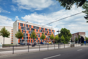  Der sanierte Plattenbau liegt an einer lauten Straße. Die ungedämmte Brüstung und die rahmenlose Schiebe-Dreh-Verglasung reduzieren im geschlossenen Zustand den Schall um 21 Dezibel 