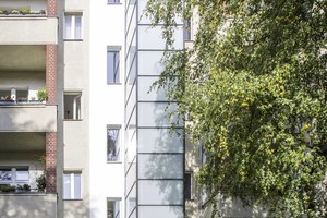  Neuer Aufzug an der Altbaufassade: Die Verkleidung des Schachtgerüsts besteht aus satiniertem Glas 