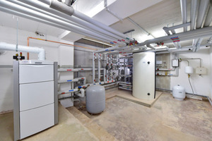  Das bodenstehende Gas-Brennwertgerät mit 65 KW modulierender Leistung plus die thermische Solaranlage versorgen die Wohnanlage; rechts der Multi-Funktionsspeicher mit 1.000 l Inhalt 