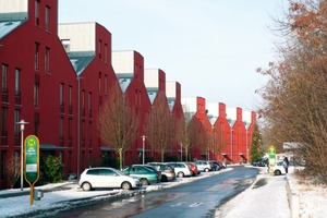  Die skulpturale Dachform der Mehrfamilienhäuser erinnert an niederländische Stadthäuser. Ihr markantes Rot ist Reminiszenz an gelbe und rote Backsteinbauten, die in Göttingen als regionaltypisch gelten.  