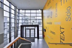  Integrierte Gesamtschule Kaufungen: Die gelbe Wand erscheint wie ein Gesamtkunstwerk. Bei Dunkelheit strahlt die Farbe schon von außen einladend durch die Glasfront 
