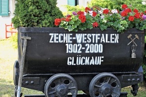  Ein blumengeschmückter Grubenhund erinnert an die Zugehörigkeit der Siedlung zur Zeche Westfalen<br /> 