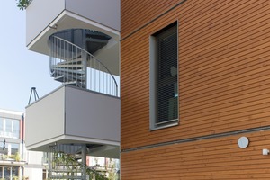  Um den Holzbaucharakter des Gebäudes zu betonen, wurden die Außenwände im Großen und Ganzen mit einer hinterlüfteten Fassadenbekleidung aus Nadelholz ausgeführt (Baustoffklasse B2 „normal entflammbar“ nach DIN 4102-1: 1998-05)  