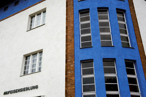  Helles, leuchtendes Blau bildet einen lebendigen Kontrast zum Weiß der Fassadenflächen und zum Rot der Klinker 