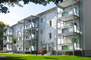 Das Mehrfamilienhaus nach der Modernisierung. Vorgestellte Balkone und Vordach-Konstruktionen verleihen dem Gebäude ein ansprechendes Aussehen 