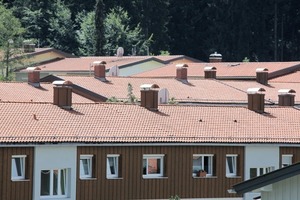  Dachlandschaften mit traditionellen roten Ziegeln und Holzverschalung im Obergeschoss 