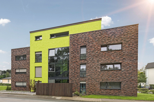  Wohngebäude in Bielefeld: Die grüne Putzfläche im Eingangsbereich schafft einen gelungenen Kontrast zur Klinkerfassade 