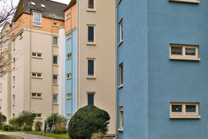  Natürliche Farben: Sandtöne im Wechsel mit Blaunuancen unterschiedlicher Helligkeiten greifen die Farben der Umgebung auf. Ein warmer Ziegelton bindet die dunklen Bitumendächer ein 